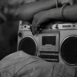 A professional radio broadcasting setup featuring a high-end microphone and DIRadioCast branding, symbolizing twenty years of independent media architecture and community-first digital storytelling.